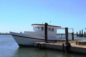 uma branco barco dentro a Porto às a golfo costa do texas. foto