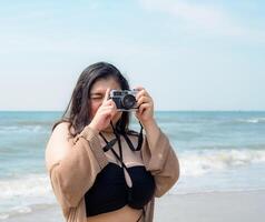 retrato jovem ásia mulher gordo gordo fofa lindo sorrir feliz Diversão apreciar relaxar bikini roupa de banho corpo sexy frente Visão mar de praia branco areia limpar \ limpo céu azul calma natureza oceano onda água viagem em feriado foto