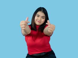 retrato menina jovem mulher ásia gordo gordo fofa lindo bonita 1 pessoa vestindo uma vermelho camisa é sentado sorridente apreciar alegremente olhando Uau para copyspace imaginário em a azul fundo foto