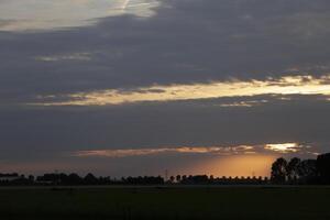 colorida pôr do sol dentro a Países Baixos foto