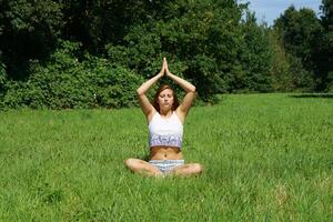 jovem mulher praticando ioga meditação ao ar livre foto