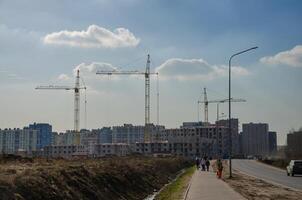 urbano construção do edifícios, guindastes em a fundo do a céu foto