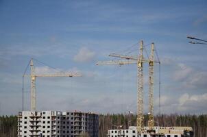 urbano construção do edifícios, guindastes em a fundo do a céu foto