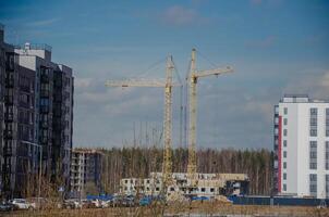 urbano construção do edifícios, guindastes em a fundo do a céu foto