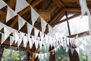 guirlandas do branco bandeiras dentro uma de madeira mirante.. verão Casamento jardim Festa. foto