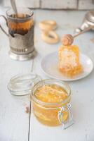 favo de mel com querida dentro uma jarra e chá a partir de uma russo samovar com bagels, orgânicos Vitamina produtos Como alternativo remédio foto