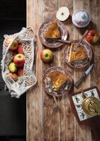 Ação de graças rústico de madeira mesa configuração com maçã torta, casa cozimento foto