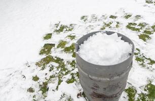 coleção do neve dentro uma tanque para obtivermos derretido água, ecológico pegada foto