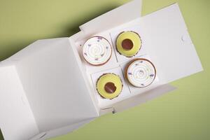 uma variedade do original bolos dentro uma branco caixa topo visualizar, cozinhando com casa Entrega foto