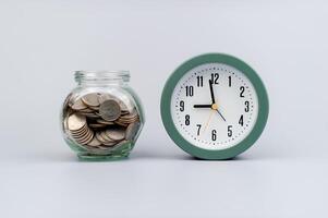 dinheiro e tempo, poupança, moedas dentro uma vidro jarra, financeiro planejamento financeiro investimento renda, dinheiro fluxo e vivo despesas foto