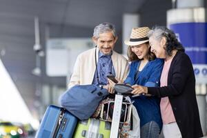 grupo do ásia família turista passageiro com Senior é usando Móvel inscrição para ligar escolher acima Táxi às aeroporto terminal para transporte durante a período de férias viagem e grandes final de semana feriado foto