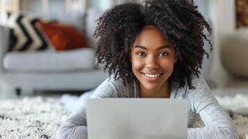 uma mulher deitado em a chão enquanto usando uma computador portátil foto