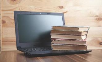 livros e laptop na mesa de madeira. foto