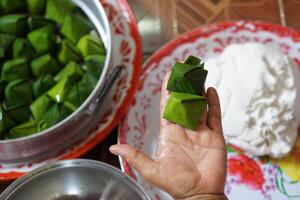mão mostrar embrulhado massa com verde banana folha para cozinhando tailandês tradicional sobremesa. conceito, tailandês Comida. quão para cozinhar, degrau do culinária. tailandês tradicional estilo de vida, preparar Comida para cultura celebração foto