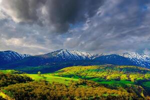 montanha topo coberto com jovem neve e iluminado de a Sol em uma ensolarado dia. montanha panorama. foto