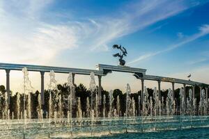 memorial e linhas do fontes iluminado de luz solar às pôr do sol ou nascer do sol dentro a independência quadrado às horário de verão, tashkent. foto