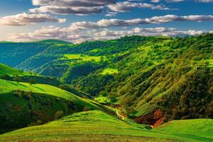 colinas e montanhas coberto com jovem verde Relva e iluminado de a Sol em uma ensolarado dia. foto