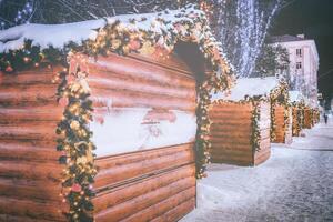 Natal ou Novo anos mercado dentro uma Europa com casas decorado com brinquedo bolas e guirlandas às noite. vintage filme estética. foto