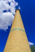 a minarete do uma tijolo mesquita contra uma nublado céu. foto