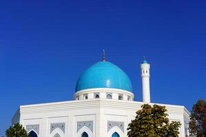 a menor mesquita coberto com branco mármore dentro a Centro do Tashkent em uma azul céu fundo. foto