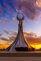 uzbequistão, Tashkent - Outubro 4, 2023 monumento do independência dentro a Formato do uma estela com uma humo pássaro em uma crepúsculo com cliody céu dentro a Novo uzbequistão parque. foto