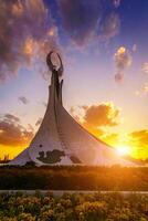 uzbequistão, Tashkent - Outubro 4, 2023 monumento do independência dentro a Formato do uma estela com uma humo pássaro em uma crepúsculo com cliody céu dentro a Novo uzbequistão parque. foto