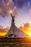 uzbequistão, Tashkent - Outubro 4, 2023 monumento do independência dentro a Formato do uma estela com uma humo pássaro em uma crepúsculo com cliody céu dentro a Novo uzbequistão parque. foto