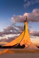 uzbequistão, Tashkent - Outubro 4, 2023 monumento do independência dentro a Formato do uma estela com uma humo pássaro em uma crepúsculo com cliody céu dentro a Novo uzbequistão parque. foto