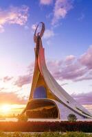 uzbequistão, Tashkent - Outubro 4, 2023 monumento do independência dentro a Formato do uma estela com uma humo pássaro em uma crepúsculo com cliody céu dentro a Novo uzbequistão parque. foto