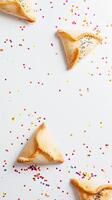 purim triangular biscoitos com hamantasch ou um homem ouvidos, colori doce para judaico feriado do purim celebração em azul papel fundo com espaço para texto. topo visualizar. foto