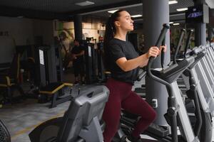 atraente jovem mulher corre em uma esteira, é acionado dentro ginástica esporte clube. foto