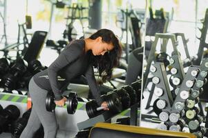 desportivo mulher dentro academia. mulher elevação pesos e trabalhando em dela peito às a academia. foto