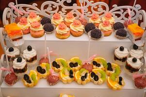 sobremesas com frutas, mousse, biscoitos. diferente tipos do doce pastelaria, pequeno colorida doce bolos, macaron, e de outros sobremesas dentro a doce bufê. doce Barra para aniversário. foto