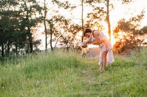 à moda mãe e bonito filha tendo Diversão em a natureza. feliz família conceito. beleza natureza cena com família ao ar livre estilo de vida. família em repouso junto. felicidade dentro família vida. mães dia. foto