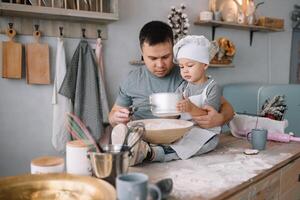 jovem homem e dele filho com forno Folha dentro cozinha. pai com pequeno filho em a cozinha. foto