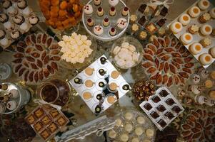 sobremesas com frutas, mousse, biscoitos. diferente tipos do doce pastelaria, pequeno colorida doce bolos, macaron, e de outros sobremesas dentro a doce bufê. doce Barra para aniversário. foto