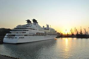 luxo cruzeiro navio Navegando para porta em nascer do sol. foto