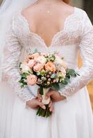 noiva carrinhos dentro uma branco Casamento vestir com uma ramalhete do flores foto