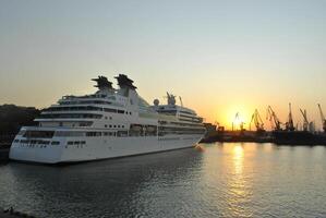 luxo cruzeiro navio Navegando para porta em nascer do sol. foto