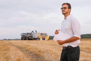 feliz agricultor em pé dentro uma trigo campo depois de a colheita. agricultura conceito. foto