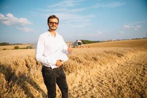 feliz agricultor dentro a campo verificação milho plantas durante uma ensolarado verão dia, agricultura e Comida Produção conceito foto