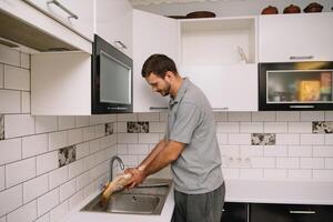 homem corte fresco peixe dentro cozinha dentro lar. homem açougueiro peixe para cozinhar. foto