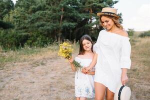 mãe e filha tendo Diversão dentro a parque. felicidade e harmonia dentro família vida. beleza natureza cena com família ao ar livre estilo de vida. mãe dia foto