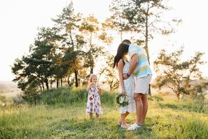 feliz família conceito - pai, mãe e criança filha tendo Diversão e jogando dentro natureza foto