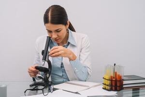 uma lindo fêmea médico ou científico investigador usando dela microscópio dentro uma laboratório. foto