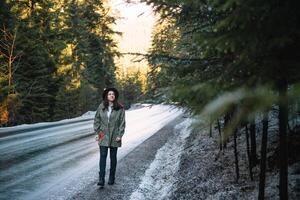 feliz menina com chapéu dentro floresta às montanha estrada fundo, relaxar Tempo em feriado conceito viagem ,cor do vintage tom e suave foco. foto