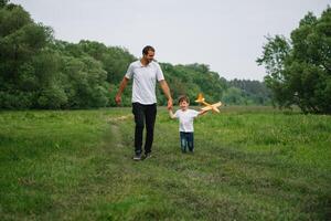 pai e filho jogando dentro aviador. Super homen Papai e filho tendo Diversão. imaginação e sonhos do ser uma piloto. criança piloto com avião em pais voltar. viagem e período de férias dentro verão. liberdade. foto