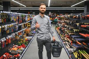 masculino construtor dentro uma hardware loja escolhe uma Ferramentas foto