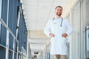 retrato do bonito jovem médico em hospital corredor foto