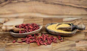 bagas de goji secas em madeira de oliveira foto